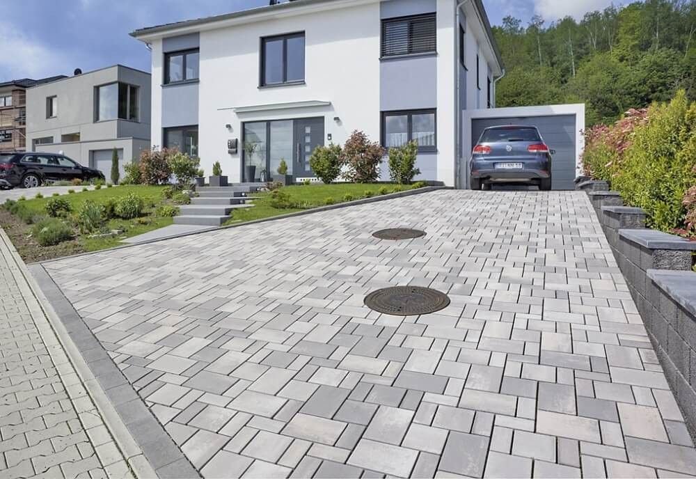Beispielhafte Einfahrt mit gepflasterter Fläche vor einem Einfamilienhaus (Beispielbild)