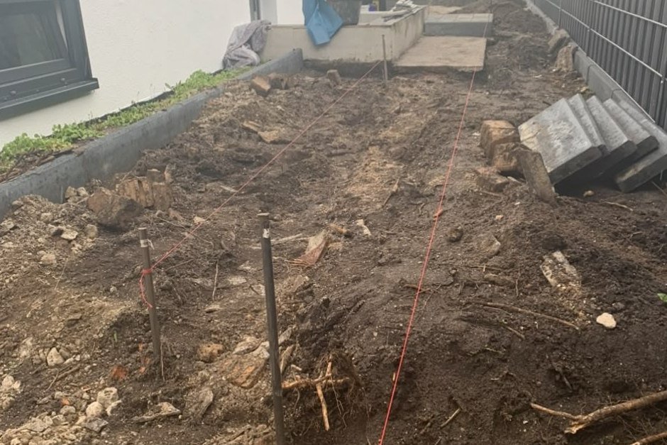 Gartenweg am Haus vor den Arbeiten: Ausgekofferter Streifen entlang der Hauswand, Schnurgerüst gespannt